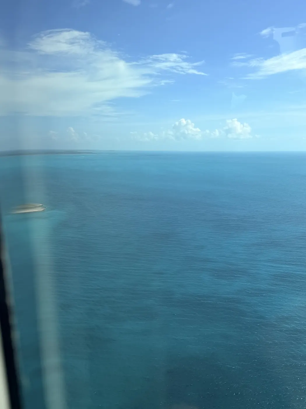 Deep blue open water under scattered cloud
